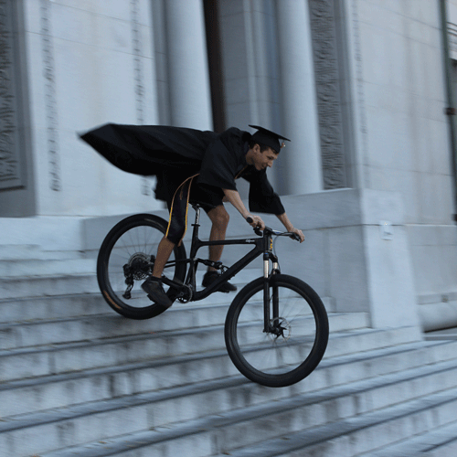 graduate mountain biking down stairs