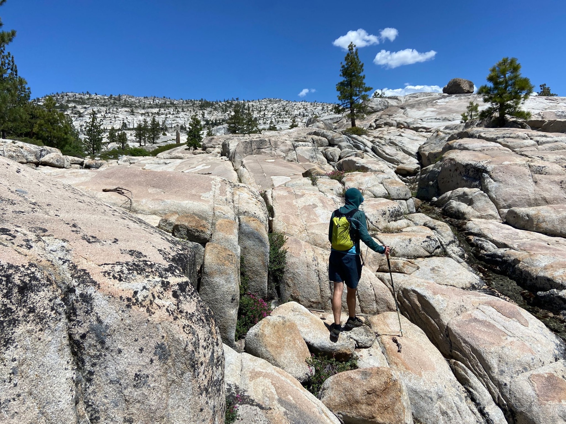 Hiker scrambling across granite slabs in Cherry Canyon