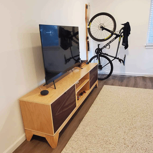 tv on tv stand and bike in corner